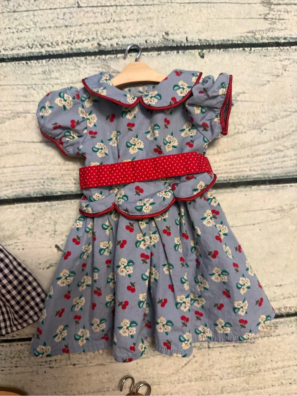 2 American girl doll dresses and 10 wood doll hangers.
